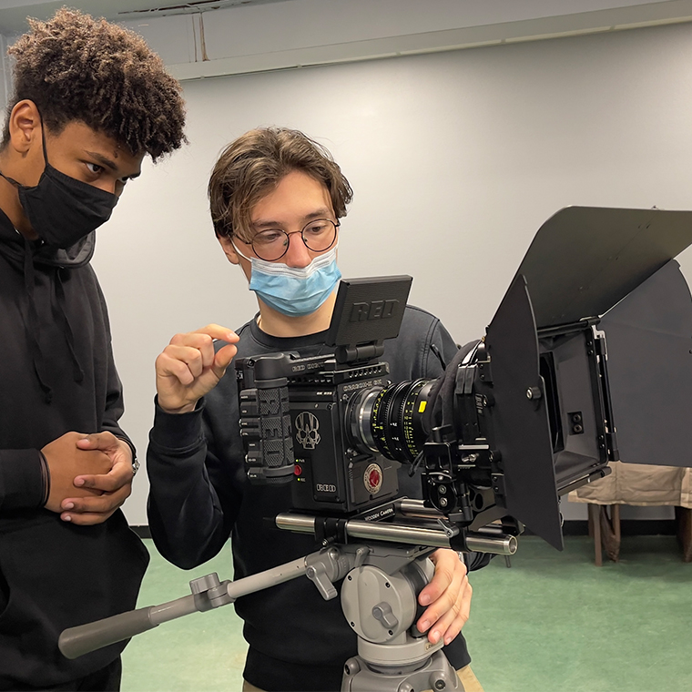 A crew making a film in a green screen studio