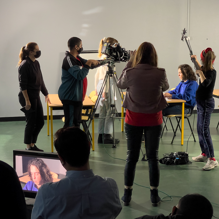 Videographer making a film with an actress at the beach